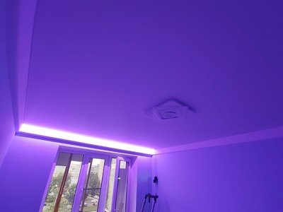 RGB-подсветка классического скрытого карниза на натяжном потолке в спальной 